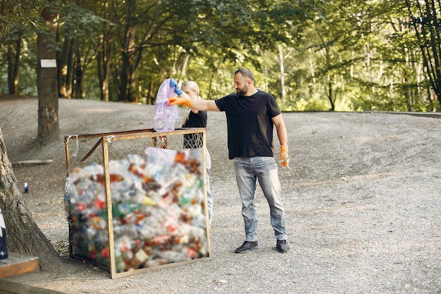 Couple collects garbage in garbage bags in park