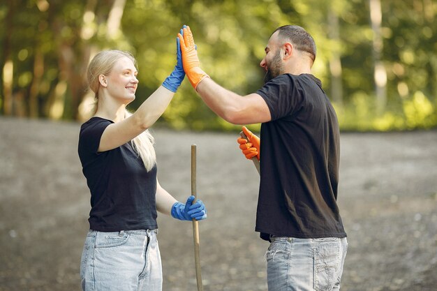 Couple collects leaves and cleans the park