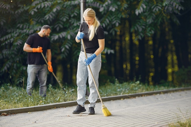 Couple collects leaves and cleans the park