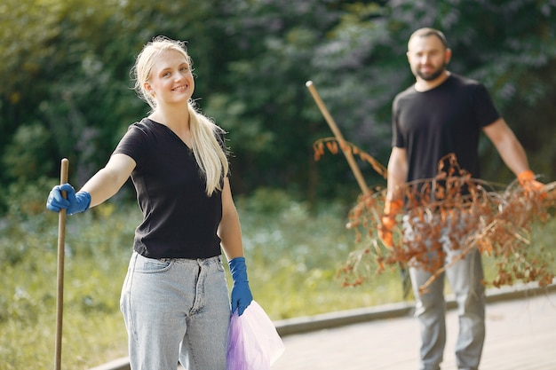 Couple collects leaves and cleans the park