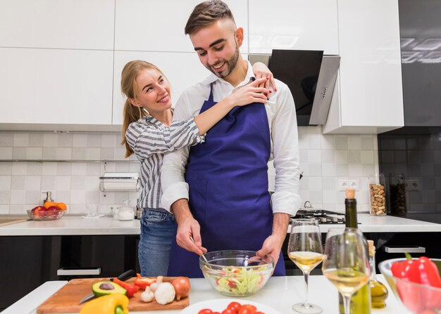 Couple cooking salad in kitchen 