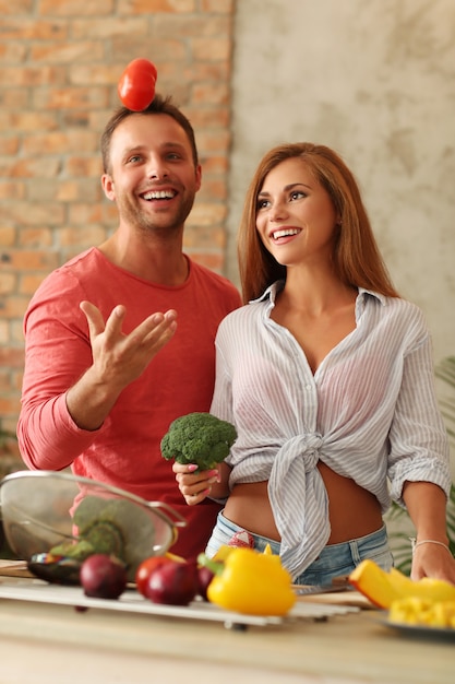 Foto gratuita coppie che cucinano le verdure in cucina