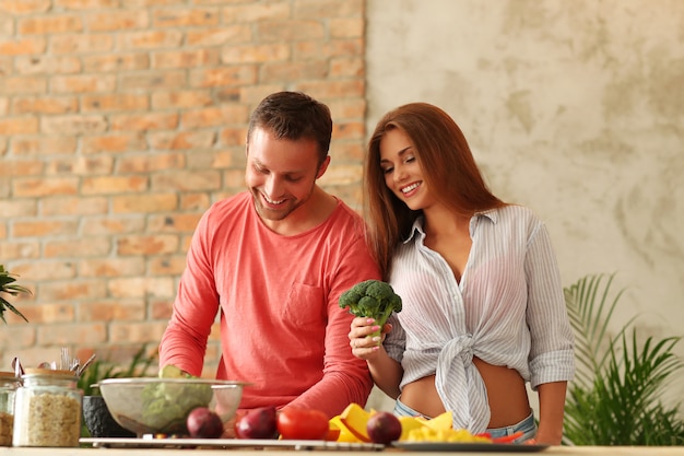 Couple cooking vegetables in kitchen