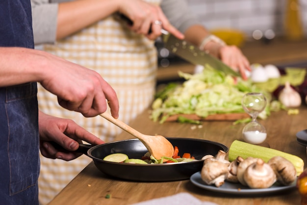 Free photo couple cooking vegetables in kitchen