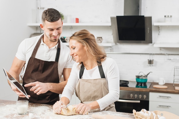 Free photo couple cooking with tablet