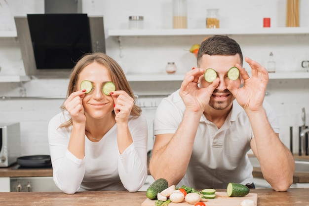 Couple covering eyes with cucumber