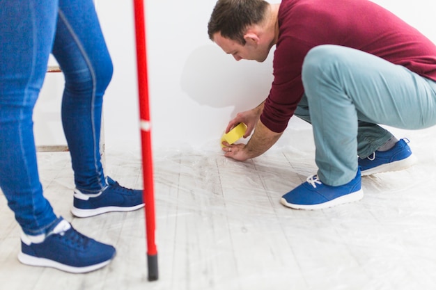 Free photo couple covering floor with protective sheet