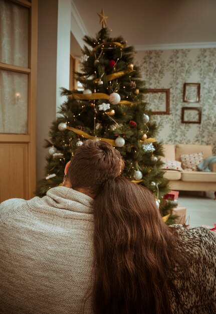 クリスマスツリーを抱きしめて見るカップル