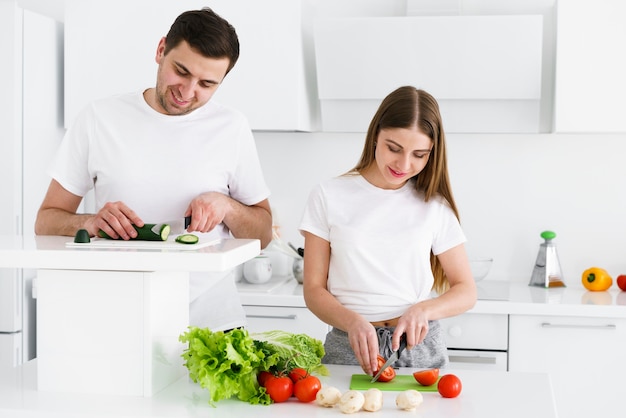 Couple cutting vegetables together