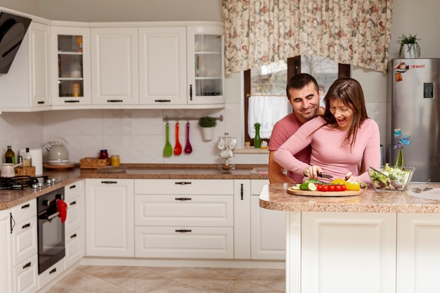 Free photo couple cutting vegetables with copy space