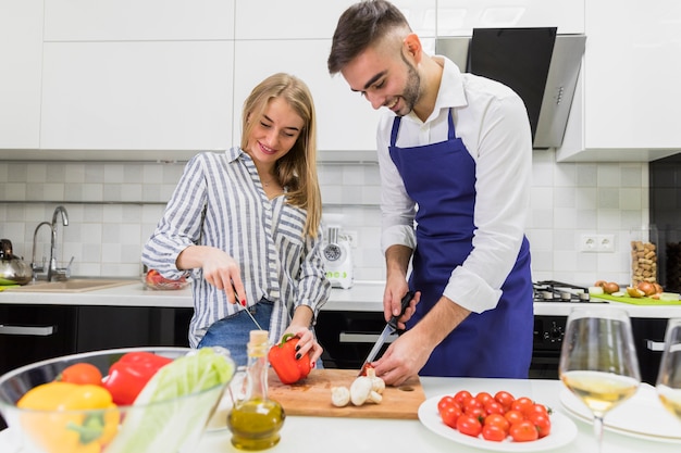 Couple cutting vegetables on wooden board