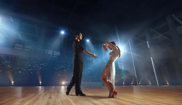 Free photo couple dancers perform latin dance on large professional stage ballroom dancing