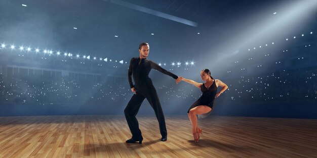 Couple dancers perform latin dance on large professional stage Ballroom dancing