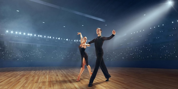 Couple dancers perform latin dance on large professional stage Ballroom dancing