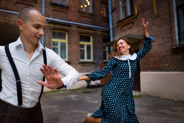 Couple dancing outdoors medium shot