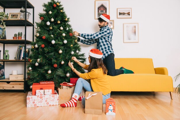 Couple decorating christmas tree