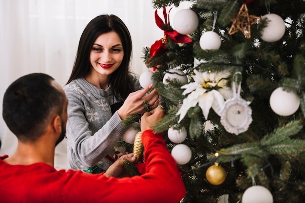 Couple decorating Christmas tree 