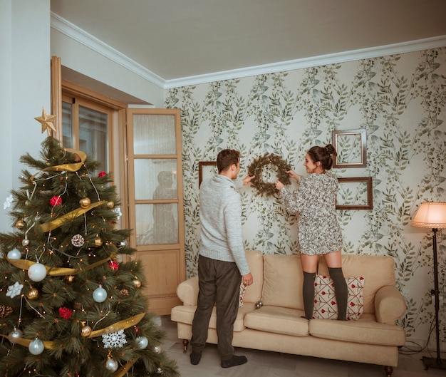 Couple decorating room for Christmas 