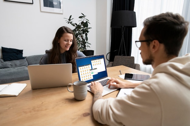 Free photo couple at desk working together from home