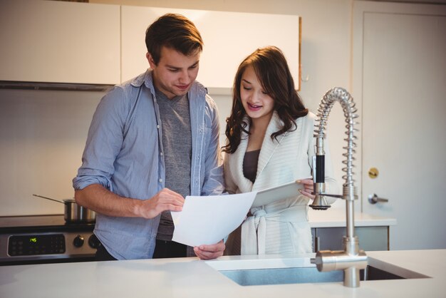 Couple discussing over digital tablet in kitchen