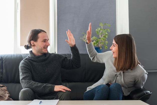 Free photo couple doing high five on couch