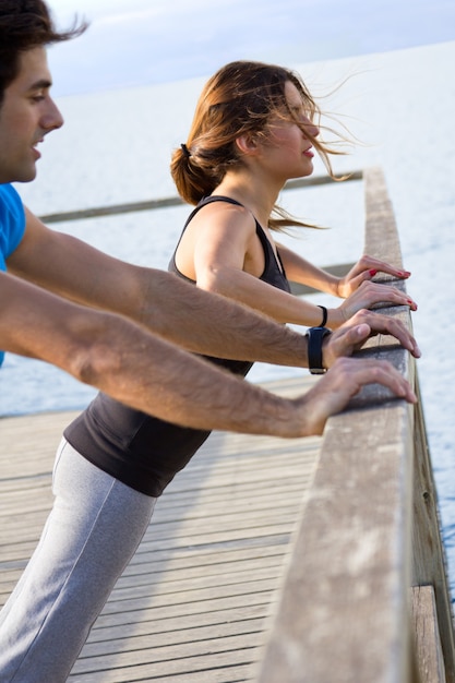 Free photo couple doing push ups near the sea