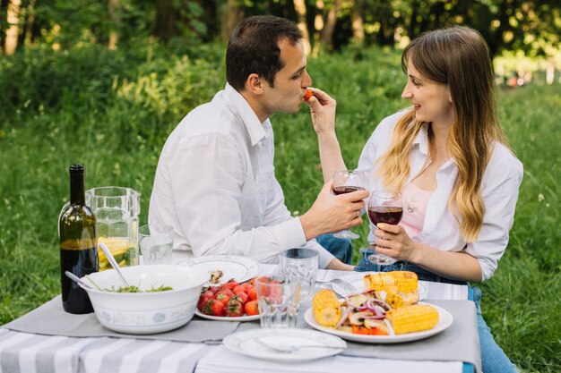 自然の中でロマンチックなピクニックをしているカップル