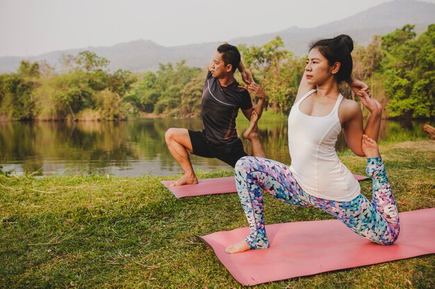 Foto gratuita coppia facendo yoga durante il tramonto