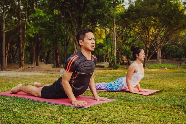 Couple doing yoga on the grass