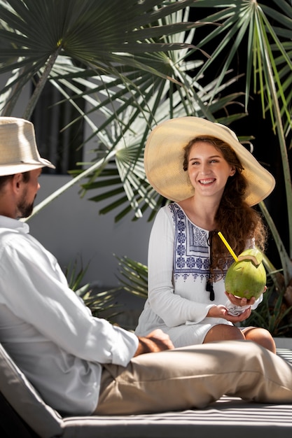 Couple drinking coconut milk by the pool during vacation