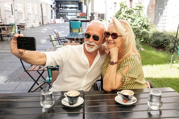 コーヒー​を​飲み​ながら​、​selfie​を​取る​カップル