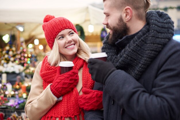 クリスマスマーケットでコーヒーを飲むカップル