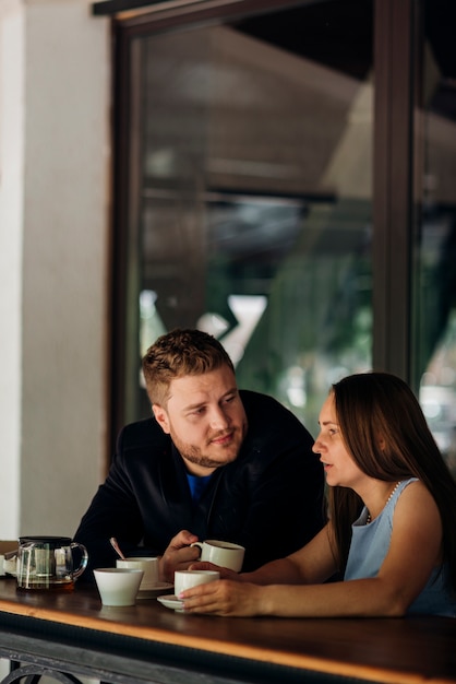 コーヒーを飲みながら、コーヒーショップで話しているカップル