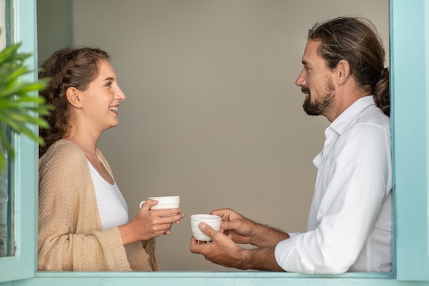 Free photo couple drinking coffee in their room during vacation