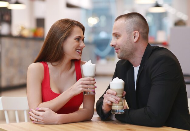 Couple drinking coffee with whipped cream