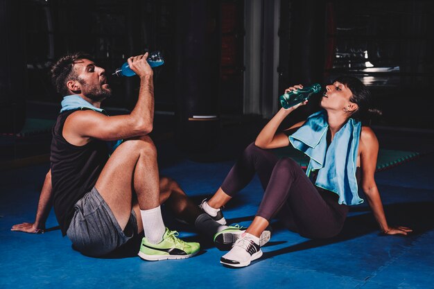 Couple drinking in gym