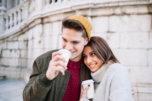 Free photo couple drinking hot beverage on walk