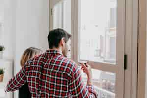 Free photo couple drinking at window