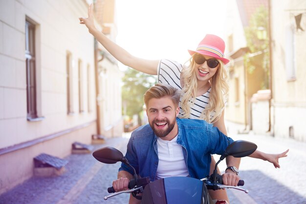 Couple driving a scooter through the city