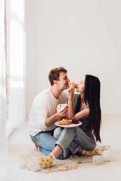 Free photo couple eating croissant