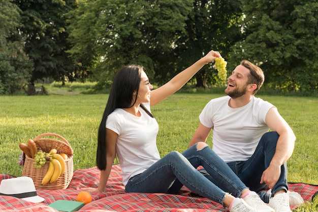 Пара ест виноград кон одеяло для пикника