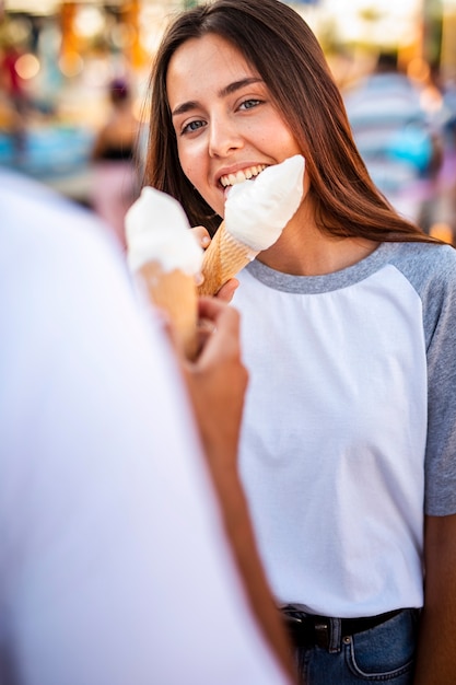 Free photo couple eating ice creams at fair