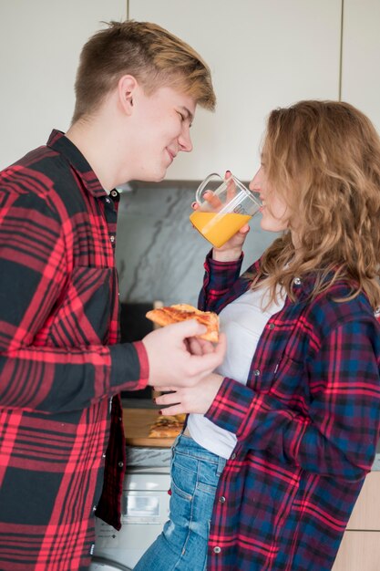 Couple eating pizza and drinking juice