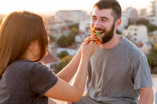 Couple eating pizza outdoors