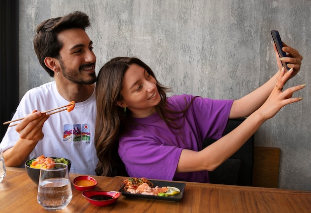 無料写真 レストランでサーモン丼を食べて自撮りするカップル