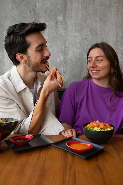 Couple eating salmon dish bowl at the restaurant