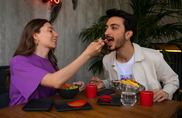 Free photo couple eating salmon dish bowl at the restaurant