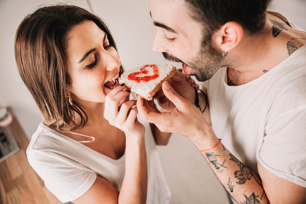 Couple eating toast with jam together