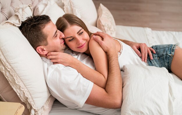 Couple embraced in bed and smiling