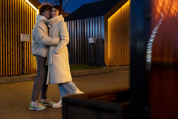 Couple embracing each other while outdoors at night
